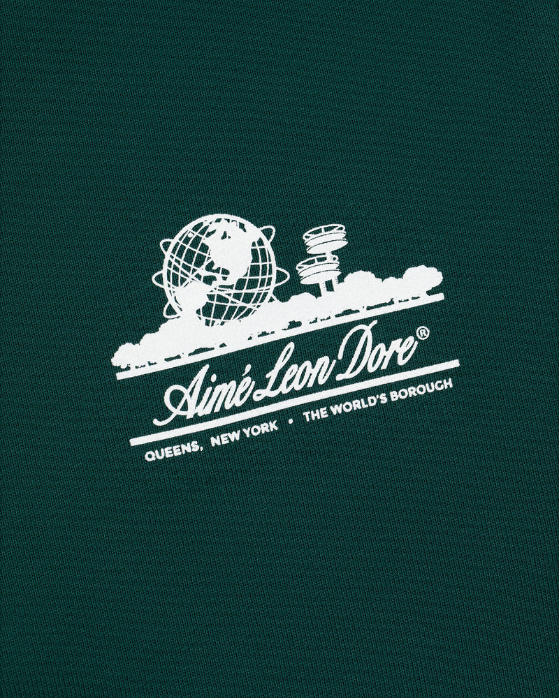 Green Unisphere Sweatpants with white Aimé Leon Dore logo, globe, cityscape, and "QUEENS, NEW YORK - THE WORLDS BOROUGH" text.