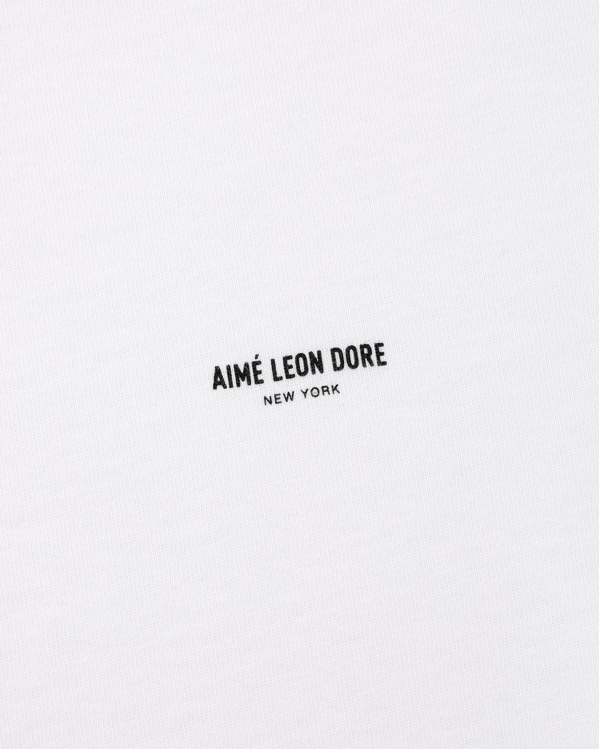 White Micro Logo Tee with black AIMÉ LEON DORE NEW YORK text printed at the center.