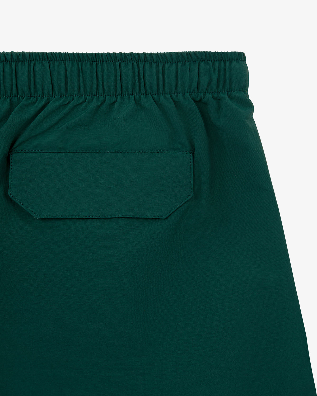 Close-up of Core Nylon Short in green, featuring an elastic waistband and a rectangular back flap pocket.