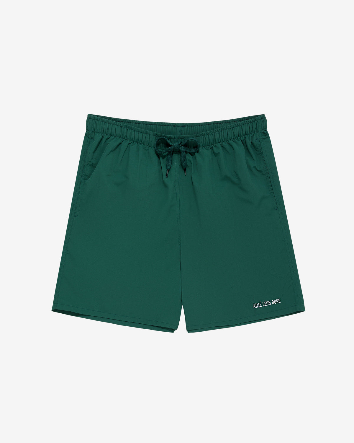 Core Nylon Short in dark green with elastic waistband, drawstring, side pockets, and small white text near hem.