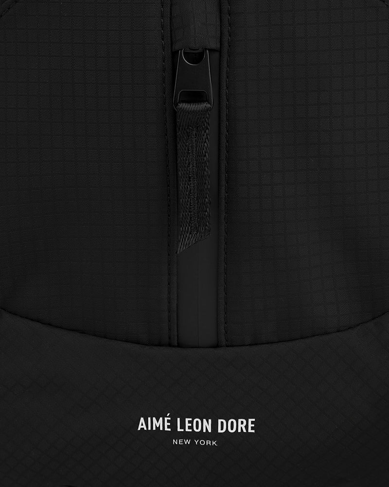 Close-up of the black Nylon Messenger Bag with a zipper and AIMÉ LEON DORE NEW YORK printed in white.