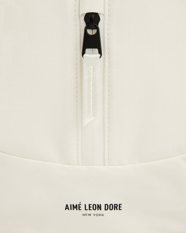 Close-up of a white Nylon Messenger Bag with a zipper and AIMÉ LEON DORE NEW YORK logo at the bottom.