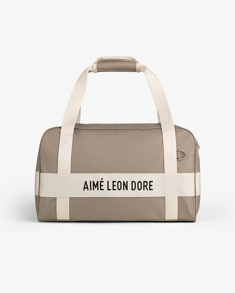 Beige Nylon Duffle Bag with white handles and "AIMÉ LEON DORE" in black on the front.