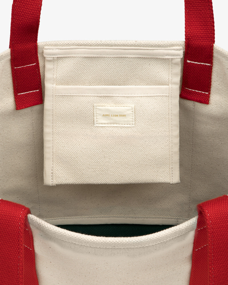 Large Crest Contrast Tote Bag with red handles and interior pocket labeled ABOVE LUCK STORE.