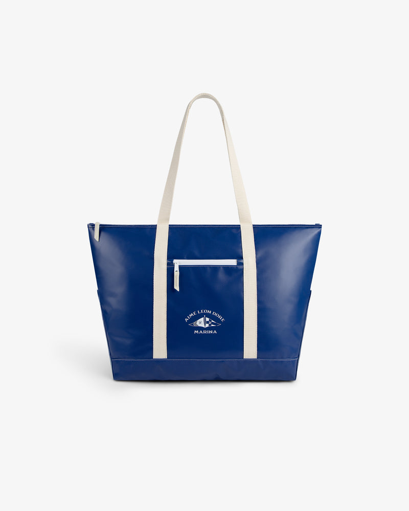 Carryall Marina Tote: blue with white handles, front zipper pocket, and white text and logo on the front.