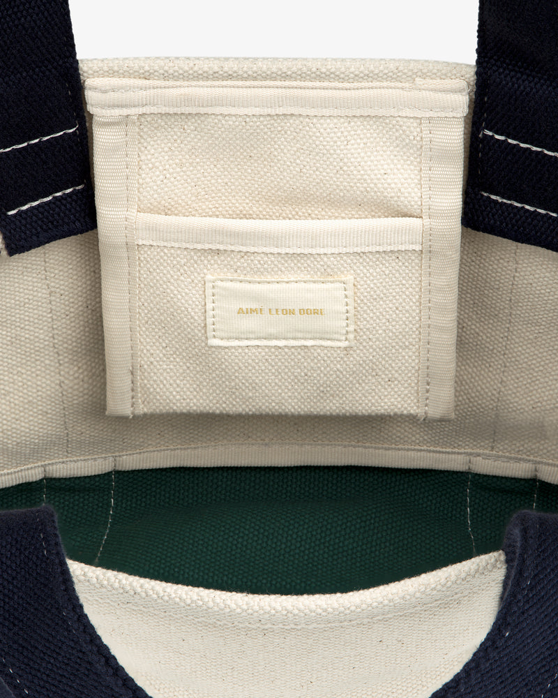 Interior of the Mini Crest Contrast Tote Bag with a small pocket and gold-stitched AIME LEON DORE label.