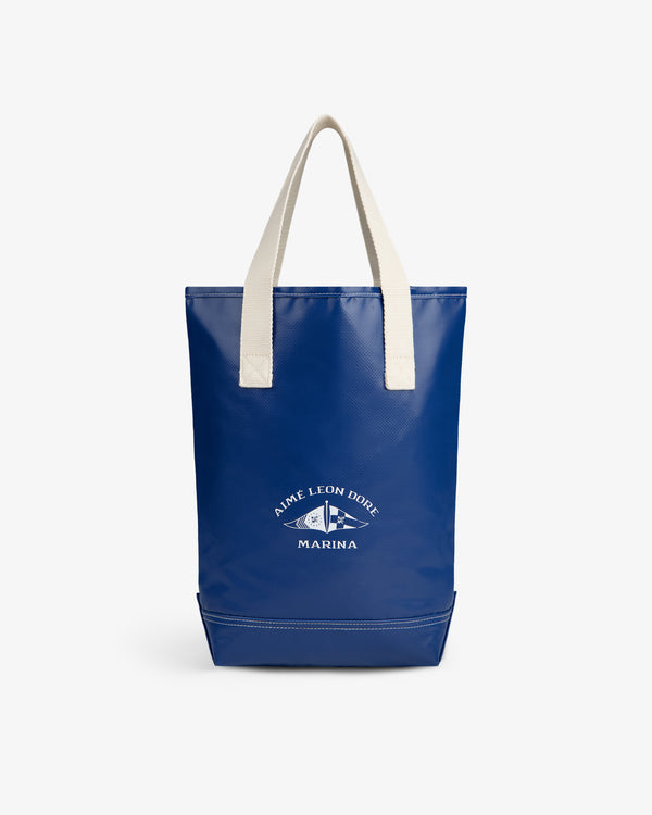 Marina Bottle Tote: Blue bag with white handles and Aime Leon Dore Marina logo printed in white on the front.