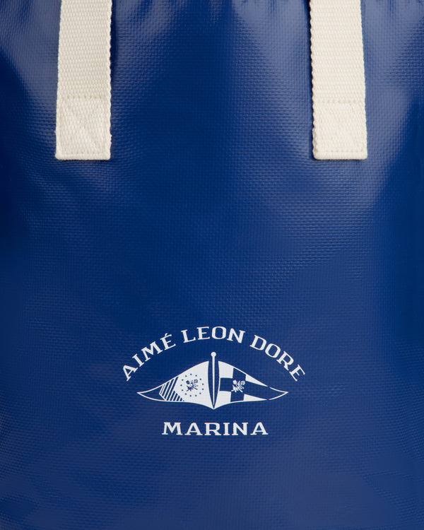 Blue Marina Bottle Tote with white handles and AIMÉ LEON DORE MARINA flag logo printed on the front.