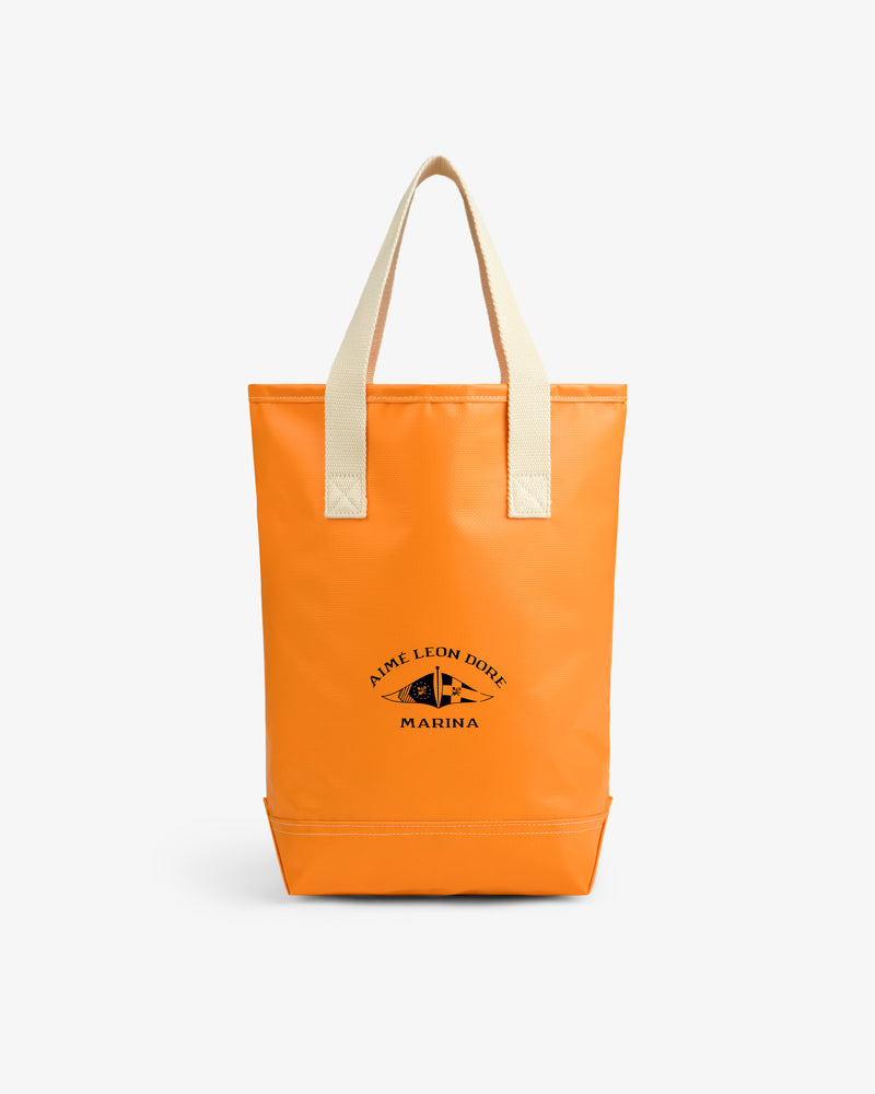 Bright orange Marina Bottle Tote with beige handles and Aime Leon Dore Marina logo printed in black on front.