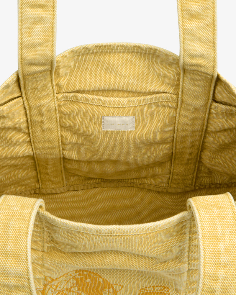 Sun Faded Large Unisphere Tote Bag in yellow canvas with sturdy handles and a small white interior label, top view.