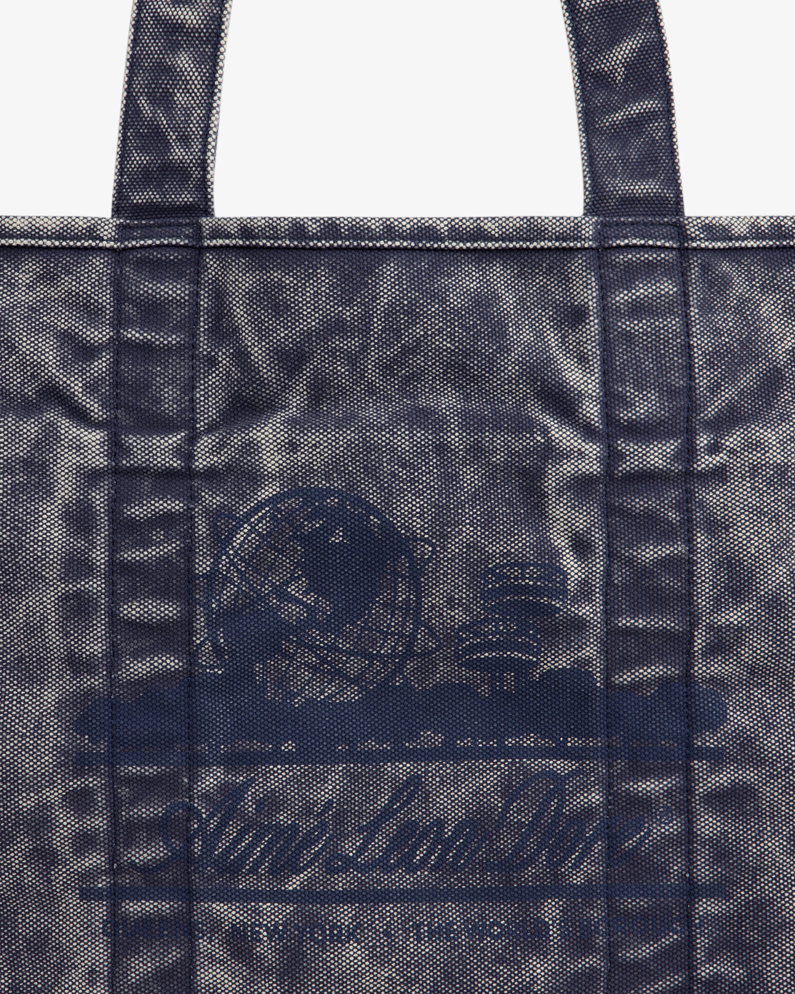 Close-up of the Sun Faded Large Unisphere Tote Bag, featuring a blue textured finish, handles, and a subtle front design.