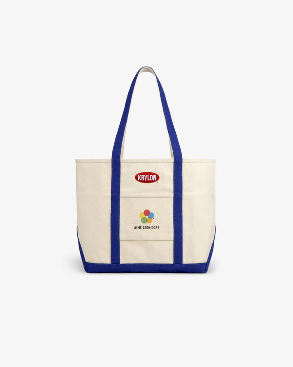 Krylon Tote Bag: Canvas tote with blue straps, KRYLON patch, and AIMÉ LEON DORE colorful front logo.