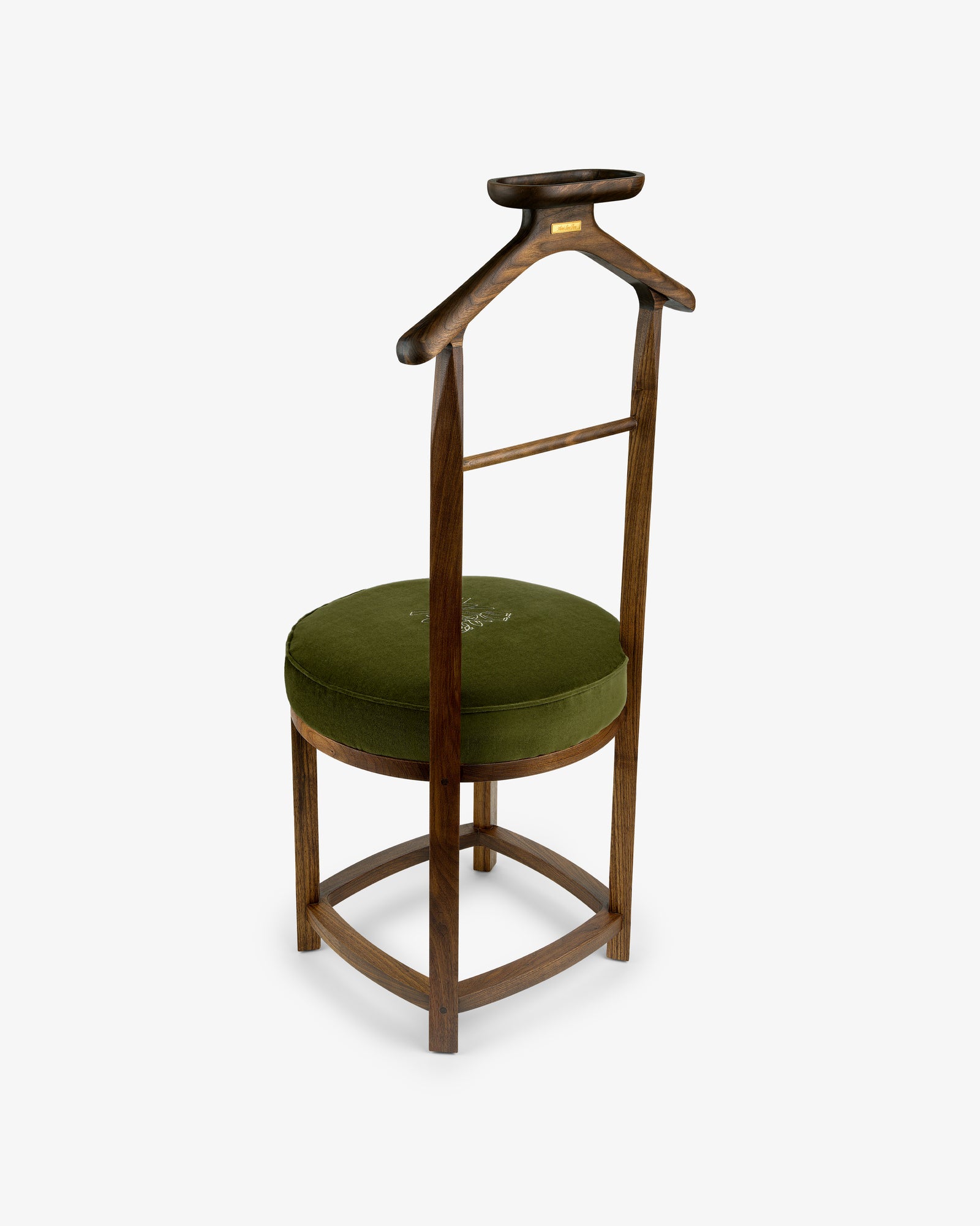 The Queens Crest Valet Chair is a wooden chair with a green cushioned seat and coat hanger-shaped backrest.
