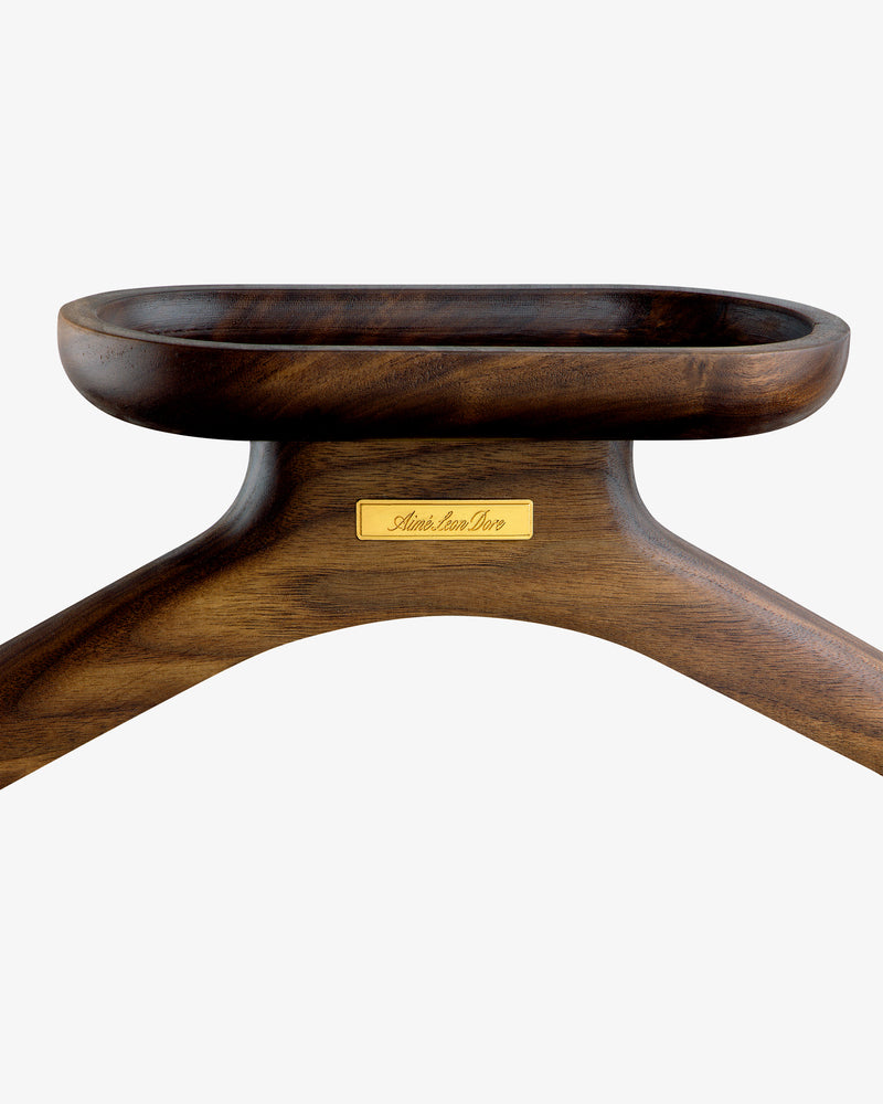 Close-up of a dark wooden Queens Crest Valet Chair featuring a gold nameplate on a white background.