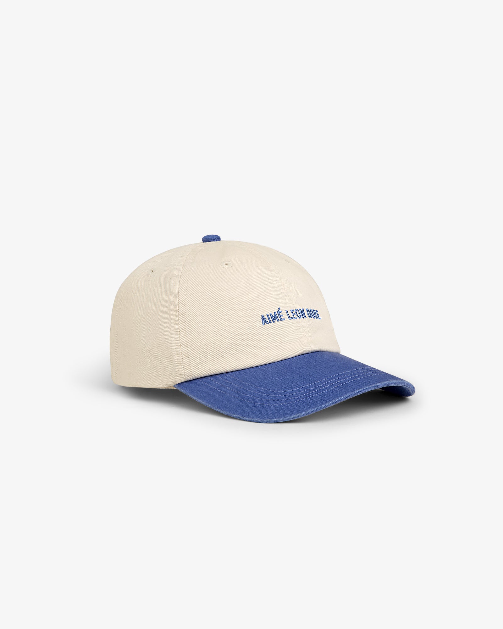 Washed Chino Hat: Beige baseball cap with blue brim and "AIMÉ LEON DORE" embroidered in blue on the front.