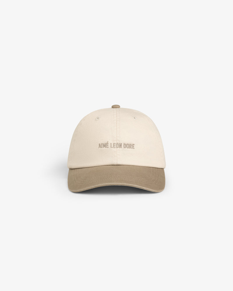 Washed Chino Hat in beige with a brown brim and AIMÉ LEON DORE logo, shown on a white background.