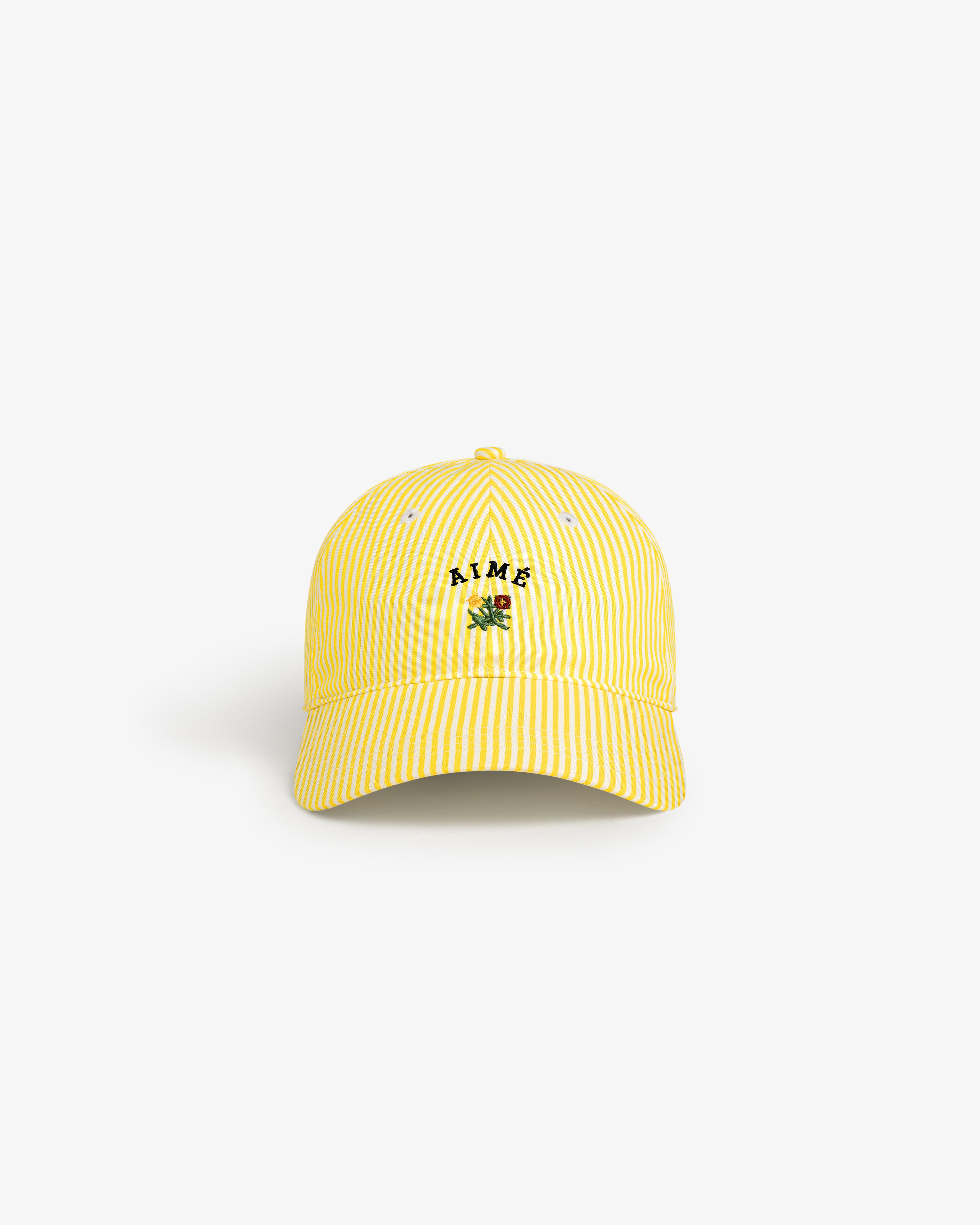 Striped Crest Logo Hat: yellow and white stripes, green plant embroidery, and "AIME" on the front.