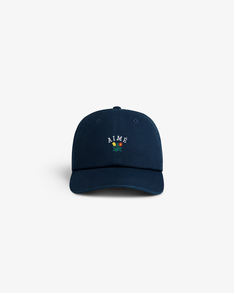 Navy blue Crest Logo Hat with AIMÉ and a small embroidered red rose on the front, shown on a white background.