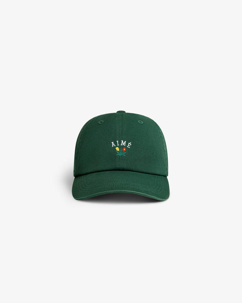 Crest Logo Hat in green with AIMÉ and small floral embroidery on the front, shown on a plain white background.