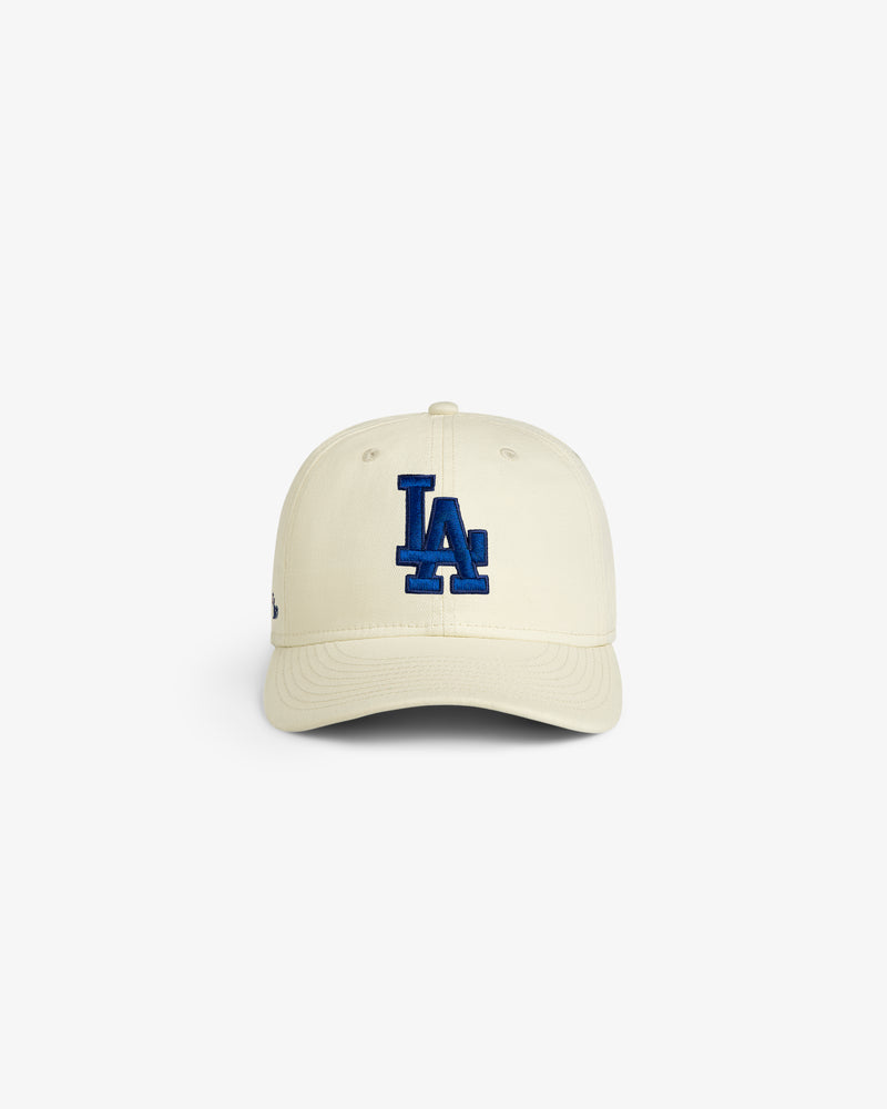 ALD / New Era Dodgers Retro Fit Hat in cream with blue LA logo, shown on a white background.