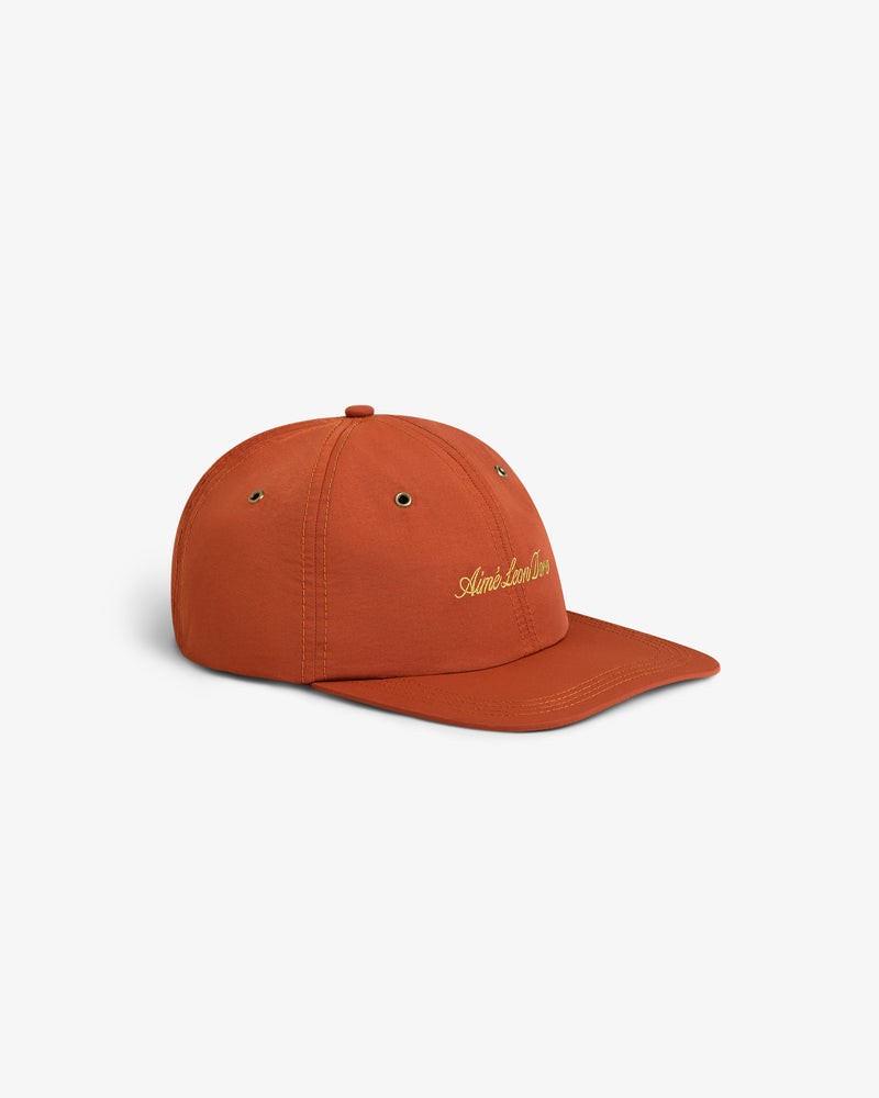 Script Sport Hat in rust with yellow embroidered text, shown on a white background.