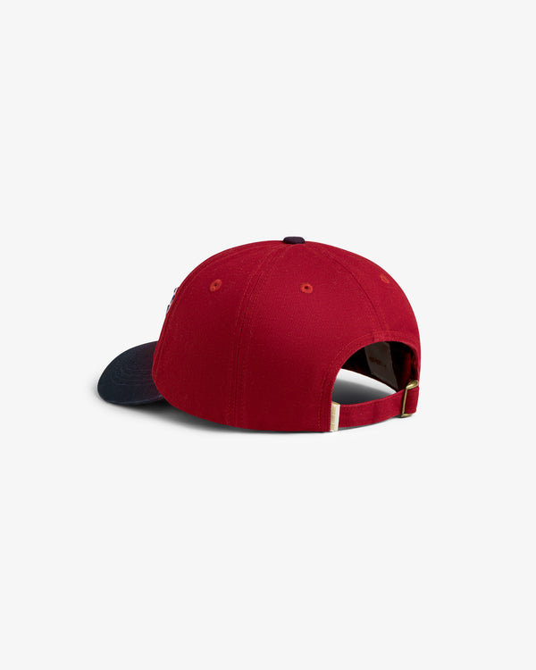Cycling Logo Hat in red with navy brim, shown from the back with adjustable strap and metal clasp.