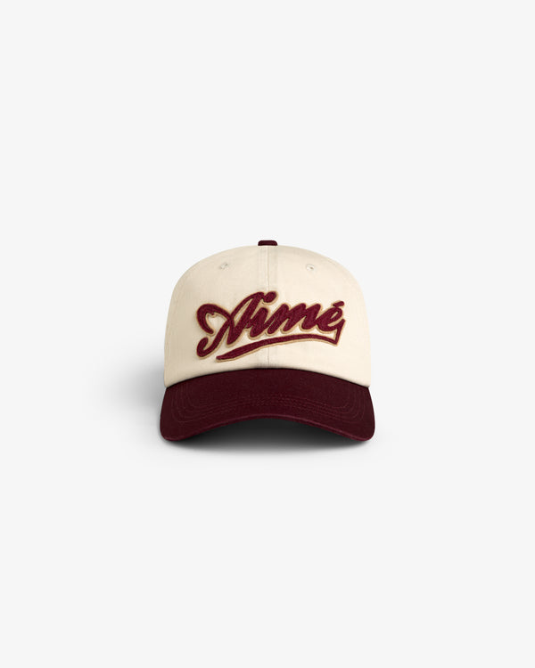 Cream Cycling Logo Hat with burgundy brim and Aimé embroidered in burgundy script on the front.