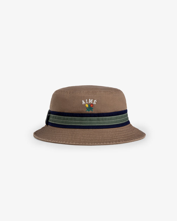 Crest Bucket Hat: brown with a navy-green striped band, AIME text, and butterfly embroidery on the front.