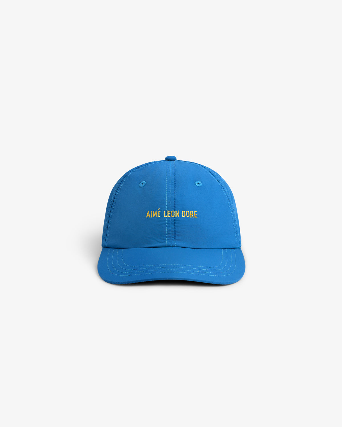 Bright blue Nylon Sport Hat with AIMÉ LEON DORE in yellow on front, shown against a white background.