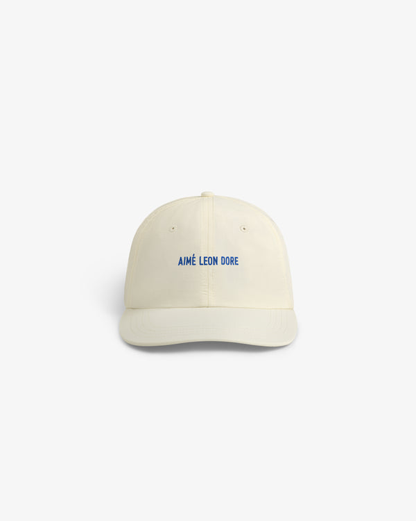 Cream-colored Nylon Sport Hat with AIMÉ LEON DORE embroidered in blue, shown against a white background.