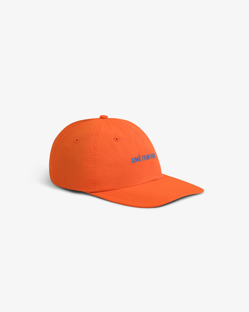 Bright orange Nylon Sport Hat with blue embroidered front text, shown on a white background.