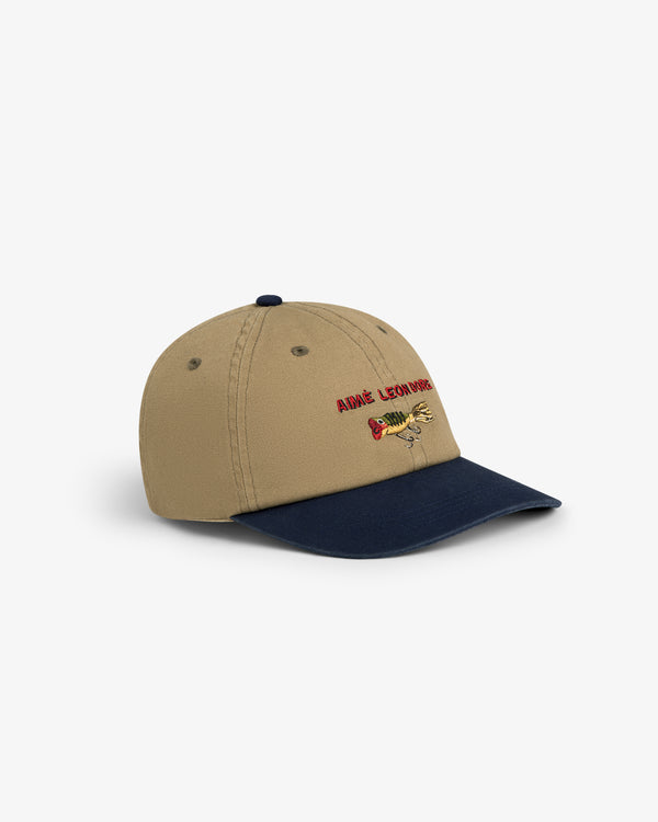 Colorblock Lure Hat: Tan cap with navy brim, colorful embroidered dinosaur, and red text on the front.