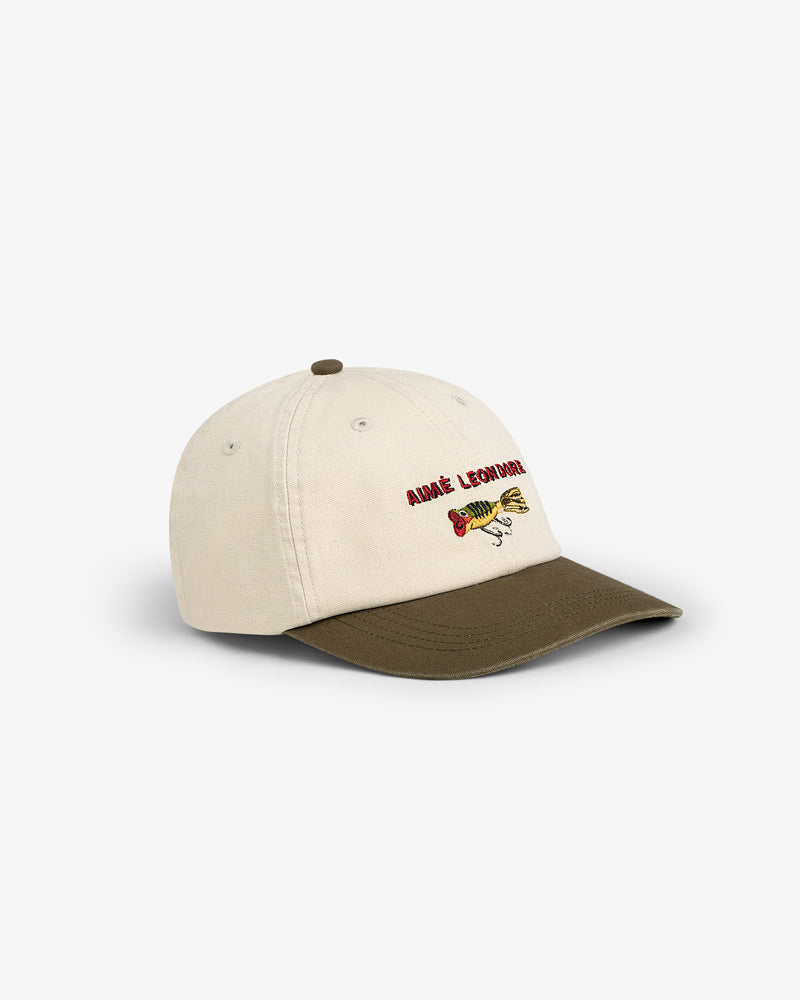 The Colorblock Lure Hat is a beige cap with a brown brim and embroidered fish and text on the front.