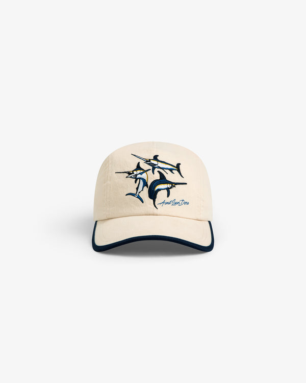 Souvenir Fishing Hat: Beige baseball cap with marlin embroidery and dark blue brim trim, shown on white background.