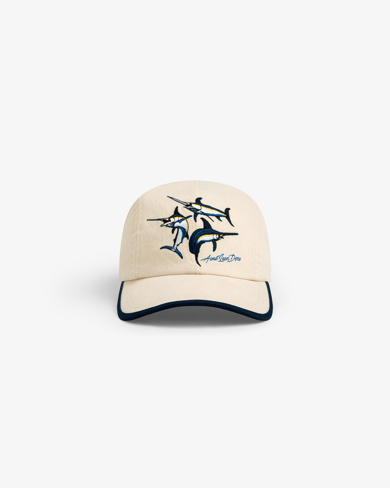 Souvenir Fishing Hat: Beige baseball cap with marlin embroidery and dark blue brim trim, shown on white background.
