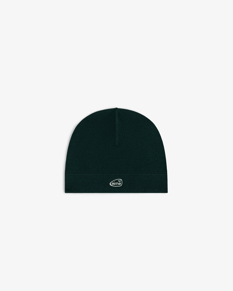 ALD Golf Skull Cap—black knit beanie with small white oval logo patch, shown on plain white background.