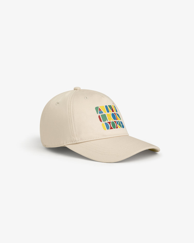 Stacked Logo Hat: beige baseball cap with colorful geometric shapes and letters on the front, shown on white background.