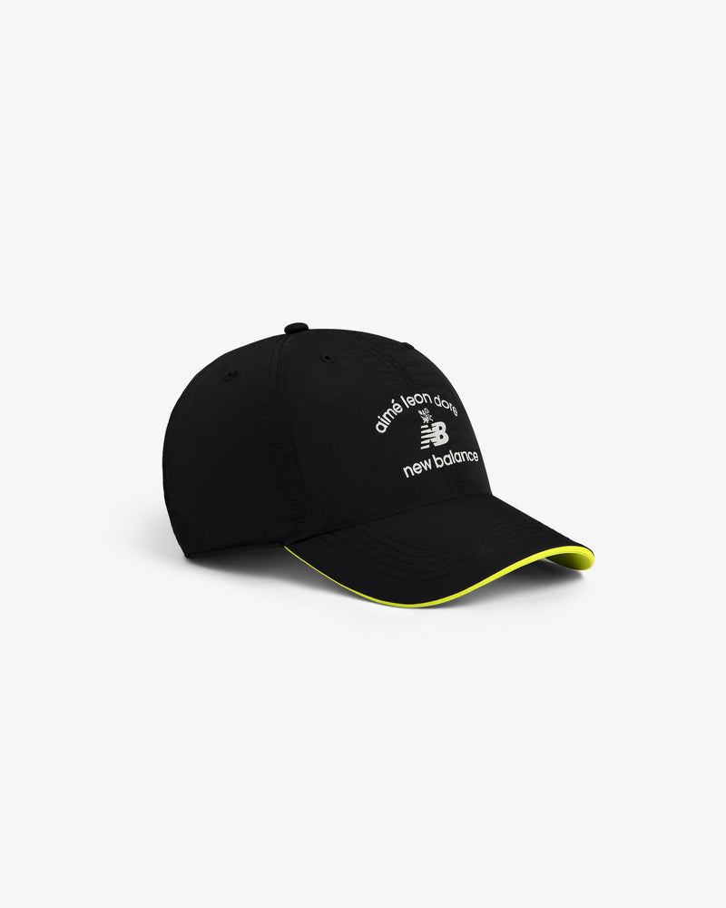 Black ALD / New Balance Running Hat with white logo and yellow trim on the curved brim, shown on a white background.