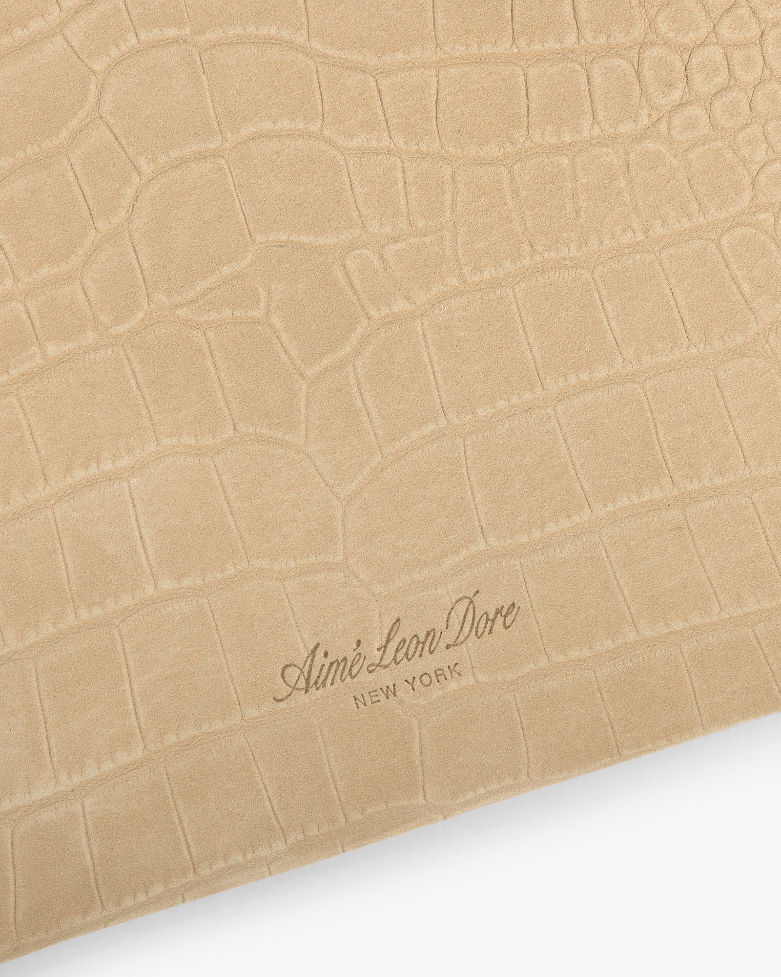 Small Croc-Embossed Nubuck Pouch featuring a tan faux-croc texture and Aimé Leon Dore New York logo at the bottom.