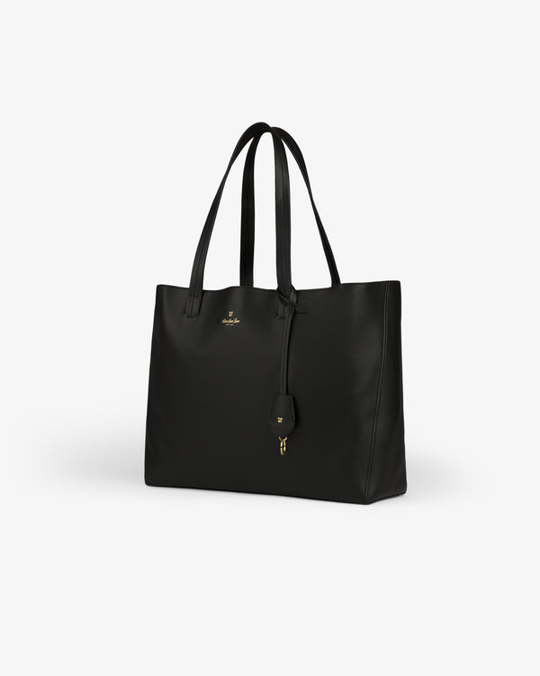 Full Grain Leather Tote Bag: black with double handles, gold logo, and small key holder on a white background.