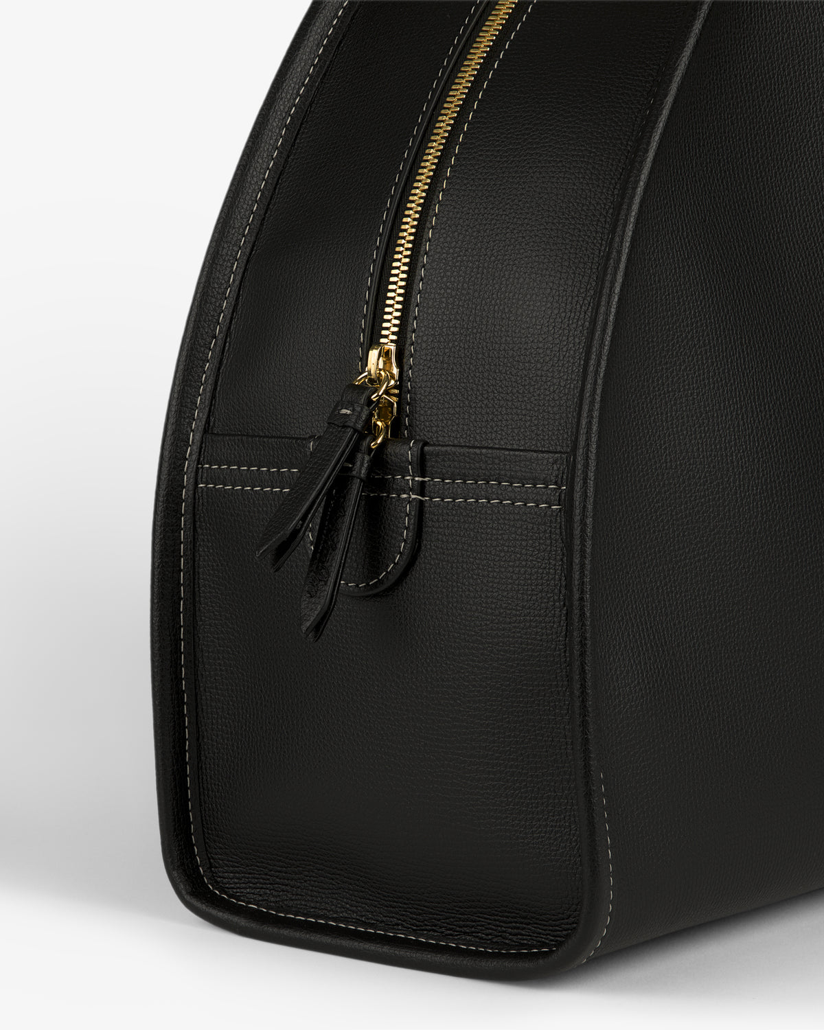 Close-up of the Full Grain Leather Weekender Bag in black with a gold zipper and visible side stitching.