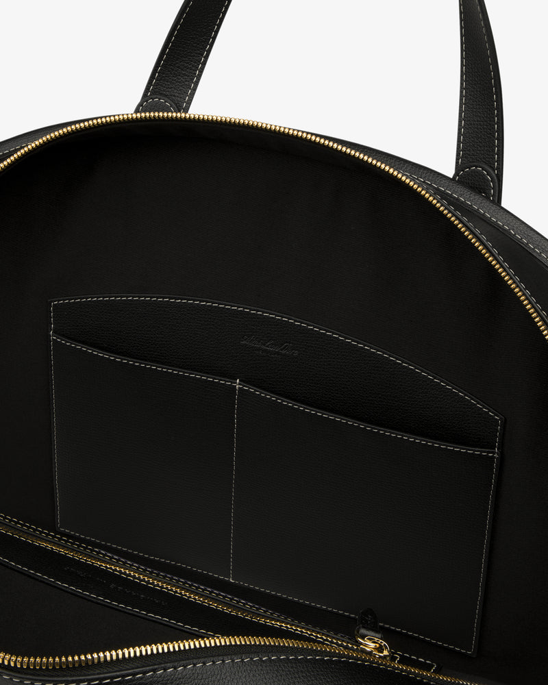 Open Full Grain Leather Weekender Bag with gold zipper, showing interior pocket and black lining on white background.