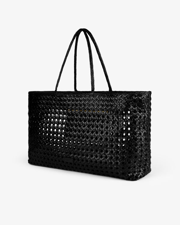 The Woven Leather Tote Bag, large and black with two handles, is shown against a plain white background.