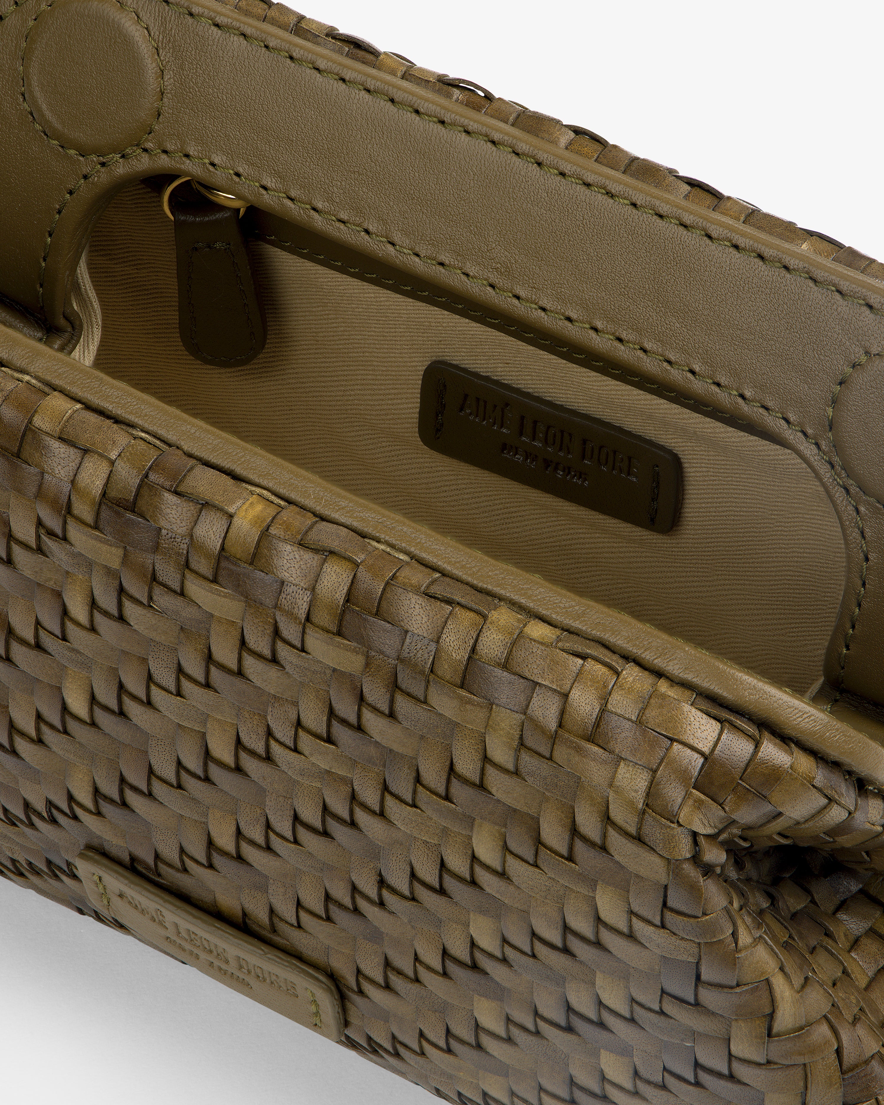 Close-up of an open Woven Leather Shoulder Bag with the embossed label and inner pocket visible.