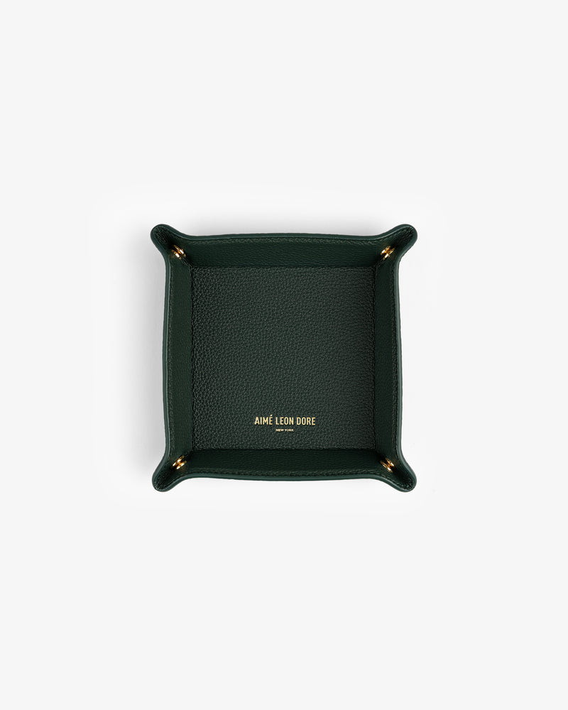 Dark green Leather Catchall with gold AIMÉ LEON DORE logo at center, photographed from above.