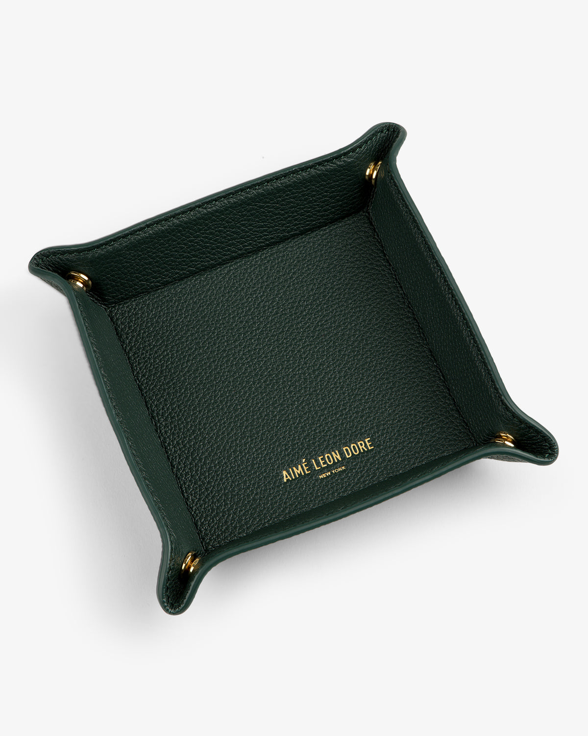 A dark green Leather Catchall with gold corner snaps and AIMÉ LEON DORE embossed in gold inside.