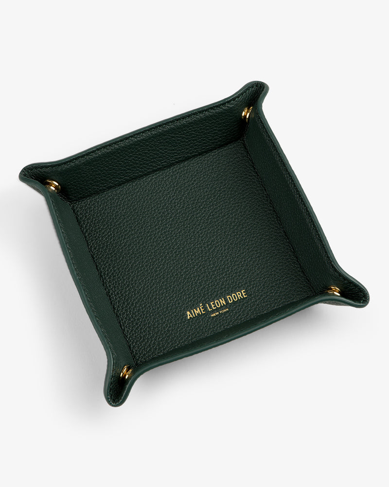 A dark green Leather Catchall with gold corner snaps and AIMÉ LEON DORE embossed in gold inside.