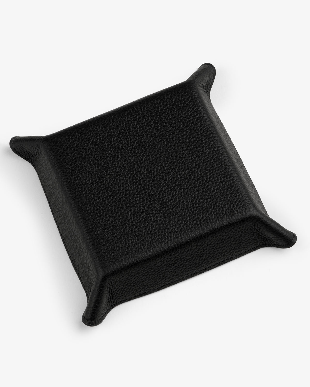 The Leather Catchall is a black leather valet tray with raised edges and pointed corners on a white background.