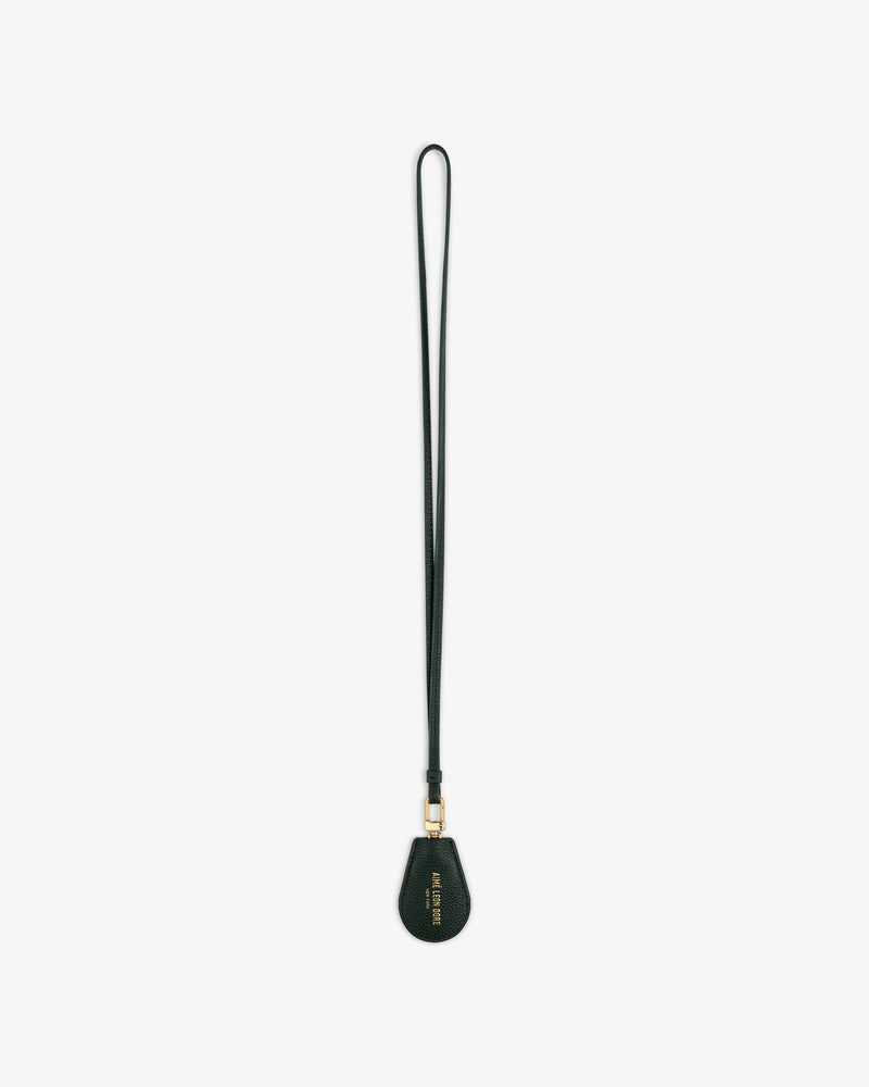 A black Leather Key Cover with a teardrop-shaped tag and gold hardware, shown on a white background.