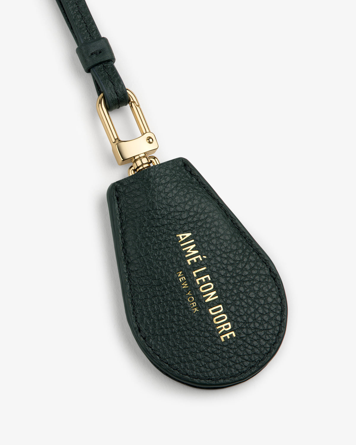 A black Leather Key Cover with gold hardware and AIMÉ LEON DORE NEW YORK printed in gold lettering.